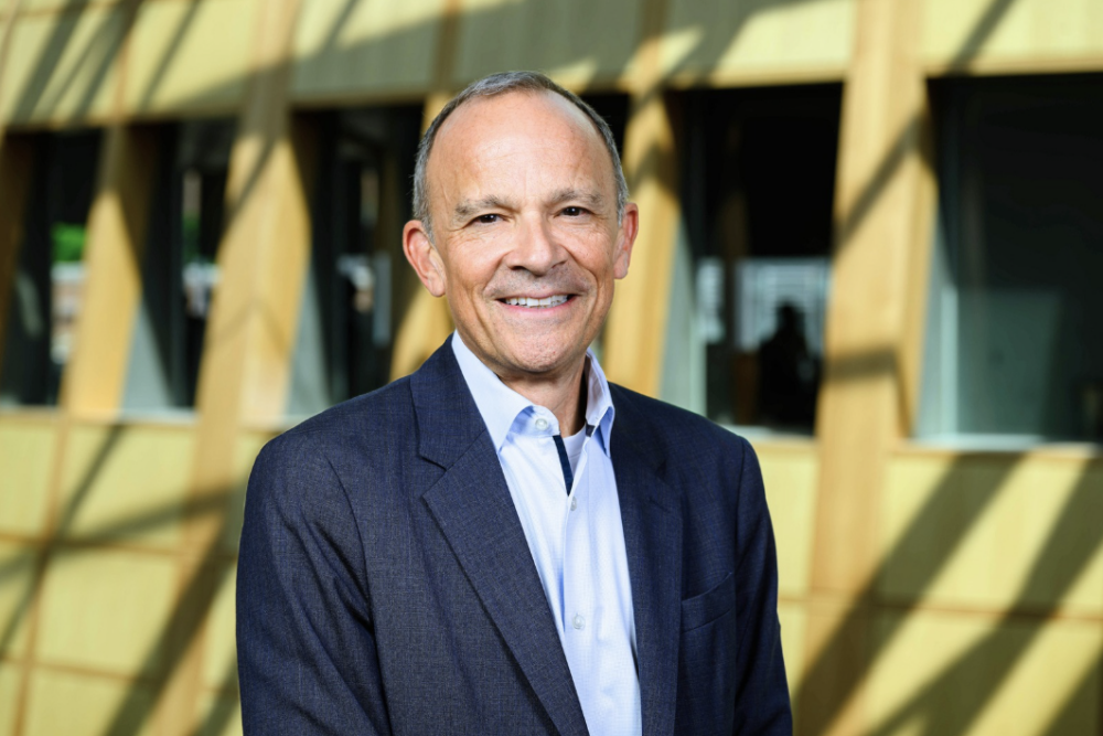 Board Member, Larry Botel in a light blue button down and a navy suit jacket.