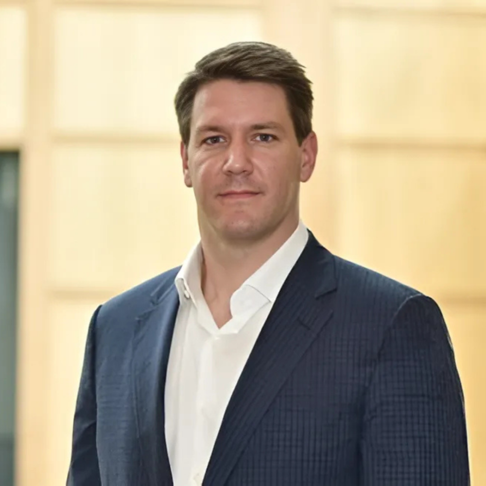 Board Member, Jonathan Cummings. Wearing a navy blue checked jacket and a white dress shirt.