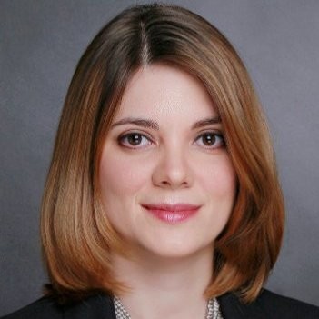 Associate Teaching Professor, Dana Popescu. Wearing a black suit jacket with a light colored dress shirt.