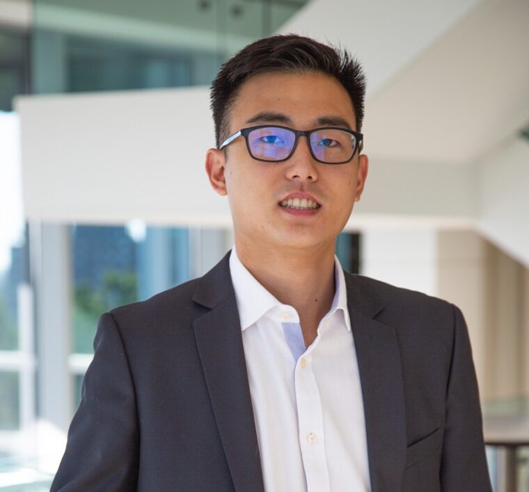 Board Member, Bryce Tsai, wearing a white button-down shirt and a dark grey suit jacket.