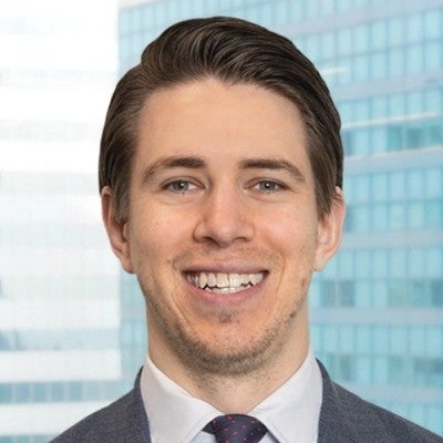 Headshot of GUREA Chair Leader Laurent Tarneaud, wearing a grey suit, navy tie and a white button down shirt.